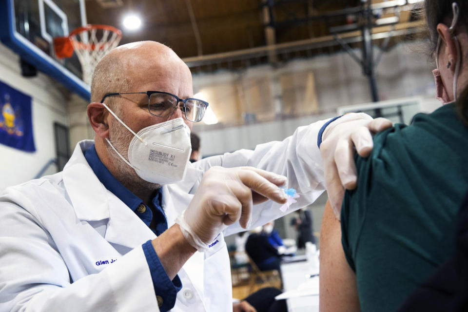 University of Scranton nursing student Glen Johnson administers the Moderna COVID-19 vaccine to a medical professional during a clinic at the Throop Civic Center in Throop, Pa. on Saturday, Jan. 9, 2021. The Lackawanna County Medical Society had about 400 doses of the Moderna vaccine on hand to administer to people in Pennsylvania's Phase 1A group of the vaccine rollout plan, which is limited to healthcare personnel and long-term care facility residents. (Christopher Dolan/The Times-Tribune via AP)