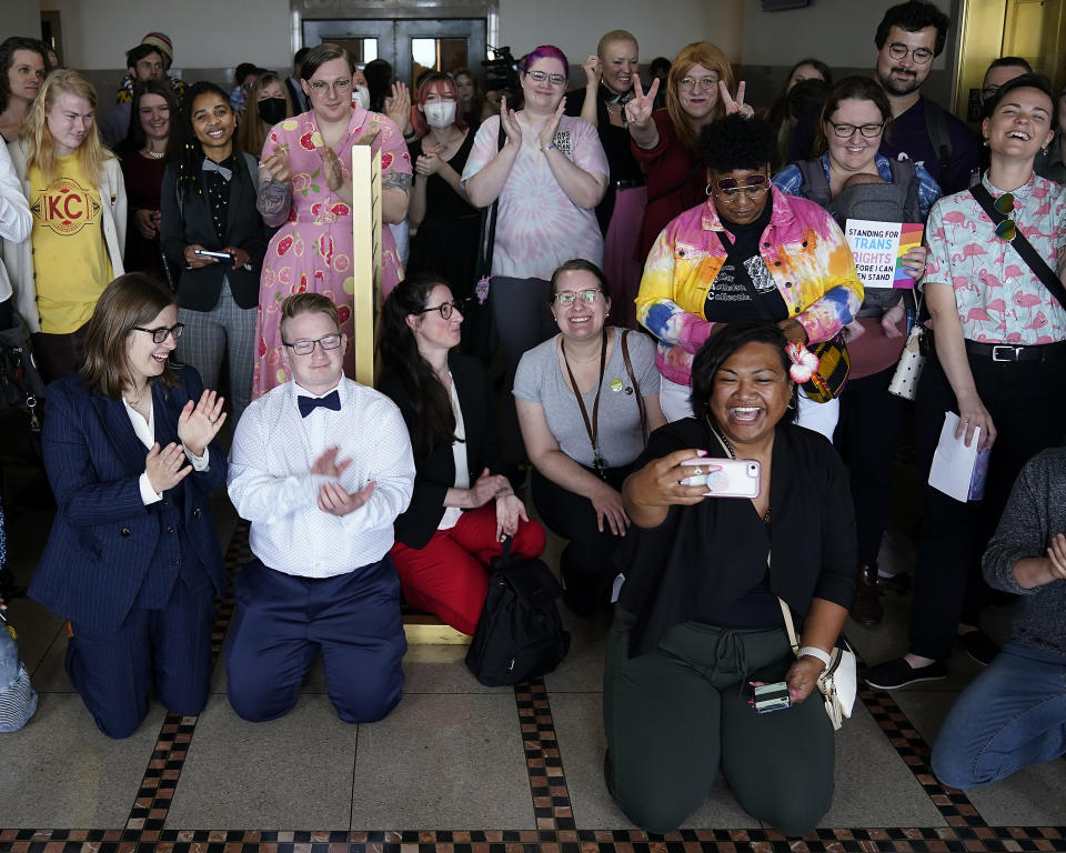 Supporters of a resolution that would make Kansas City, Mo, a sanctuary city for transgender people celebrate outside of city council chambers after a committee approved the resolution, sending it to the full council for consideration, Wednesday, May 10, 2023, in Kansas City, Mo. The move comes in the wake of Missouri legislators voting to ban gender-affirming care and trans athletes. (AP Photo/Charlie Riedel)