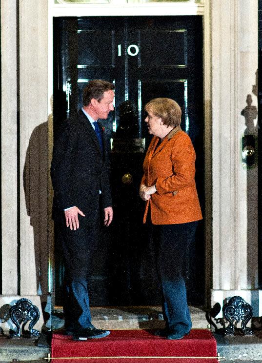 Britain's Prime Minister David Cameron, left, talks to German Chancellor Angela Merkel, right, as they pose for the media before their meeting at 10 Downing Street, in London, Wednesday, Nov. 7, 2012. The Prime Minister said at a recent EU summit in Brussels that he would veto any proposal for the next seven-year budget framework that went above a freeze on the current position, this, in turn, allegedly left the German Chancellor prepared to scupper a summit of European leaders due on 22-23 November on the EU budget unless David Cameron withdraws the threat of a blanket veto. (AP Photo/Bogdan Maran)