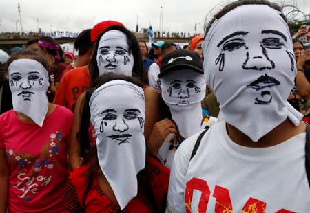 FILE PHOTO: Activists wear hoods depicting families of victims killed in President Rodrigo Duterte's drug war as Duterte delivers his State of the Nation address in Quezon city, Metro Manila