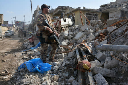 A member of the Counter Terrorism Service (CTS) stands at the site after an air strike attack against Islamic State triggered a massive explosion in Mosul, Iraq March 29, 2017. REUTERS/Stringer FOR EDITORIAL USE ONLY. NO RESALES. NO ARCHIVES.