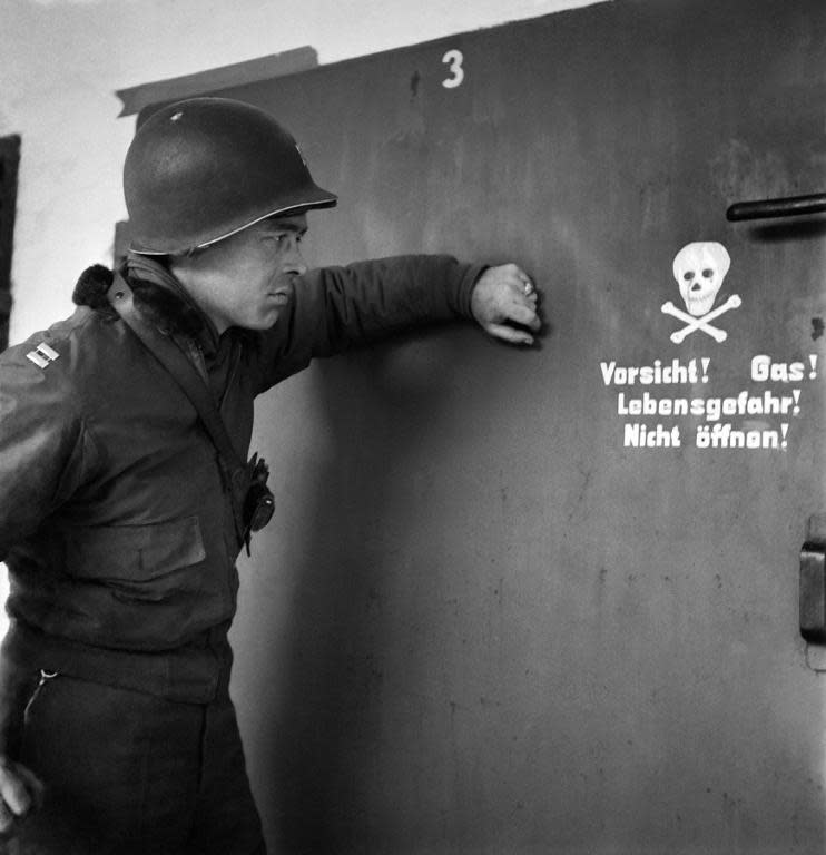 A picture taken in April 1945 shows a US soldier in front of the door of a gas chamber at the Nazi concentration camp of Dachau after its liberation by Allied troops