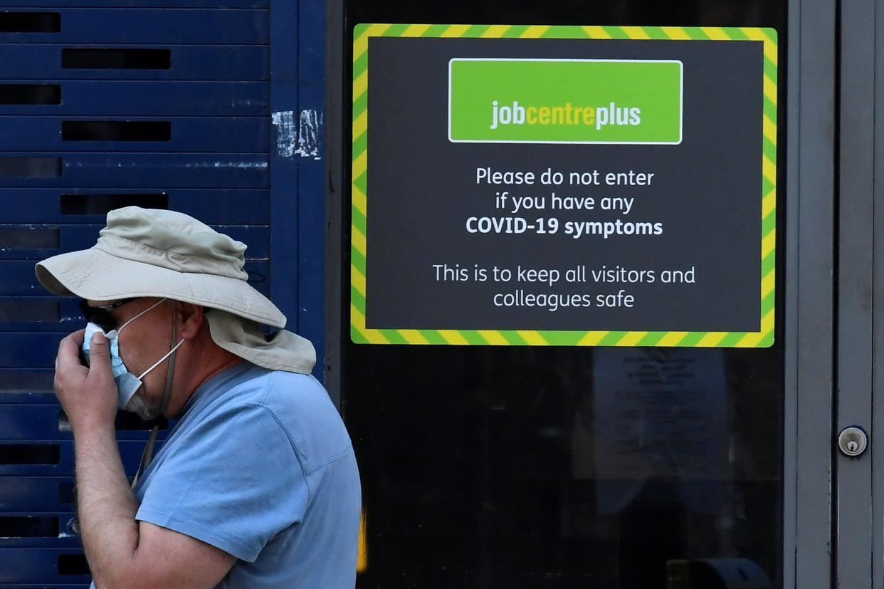 A person wearing a protective face mask walks past a Job Centre Plus office, amidst the outbreak of the coronavirus disease (COVID-19) in London, Britain, August 11, 2020. REUTERS/Toby Melville