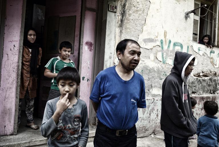 A family stands outside their apartment building at the Prosfygika complex in central Athens on October 29, 2014