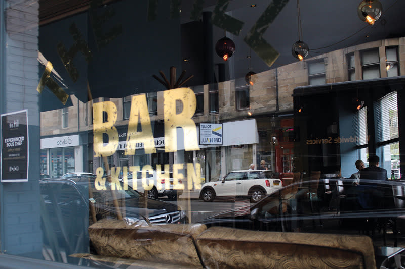 <p>A Busy street is reflected in the glass of a bar in Glasgow. (Hannah Faith Jackson)</p>