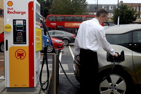 A member of staff charges an electric car at the Holloway Road Shell station where Shell is launching its first fast electric vehicle charging station in London, Britain October 18, 2017. REUTERS/Mary Turner