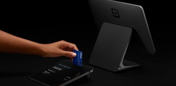 A customer uses a chip reader built into Square Register