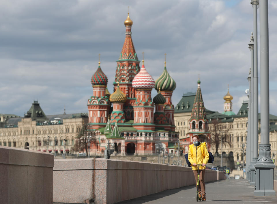 A courier of the Yandex.Eda food delivery service riding a bicycle in Bolshoi Moskvoretsky Bridge overlooking St Basil's Cathedral during the ongoing COVID-19 coronavirus pandemic