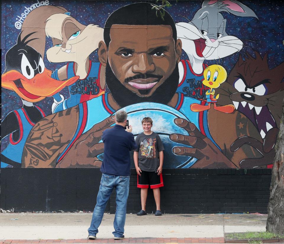 Mike Plybon of Norton takes a photo of his son Austin, 14, with the LeBron James "Space Jam" mural on West Market and North Valley Street on Wednesday July 21, 2021.