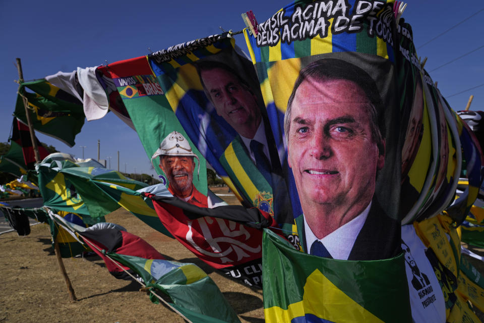 Presidential election campaign flags featuring the faces of both current President Jair Bolsonaro, front, and former President Luiz Inacio Lula da Silva hang for sale outside the Supreme Electoral Court in Brasilia, Brazil, Monday, Sept. 5, 2022. Brazil will hold its first round of general elections on Oct. 2 and second round on Oct. 30. (AP Photo/Eraldo Peres)
