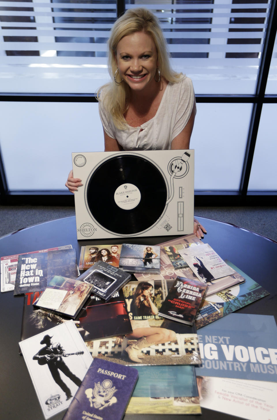 In this Oct. 30, 2013 photo, Brandi Simms, director of membership and balloting for the Country Music Association, displays products sent to influence voters of the CMA Awards in Nashville, Tenn. The CMA encourages artists and their labels to educate voters, allowing three email blasts and one mailed product a year. (AP Photo/Mark Humphrey)