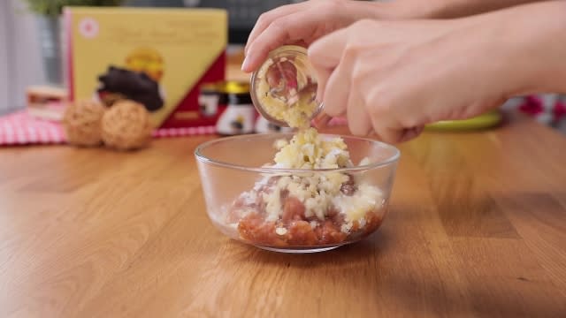 Adding chopped garlic to minced pork