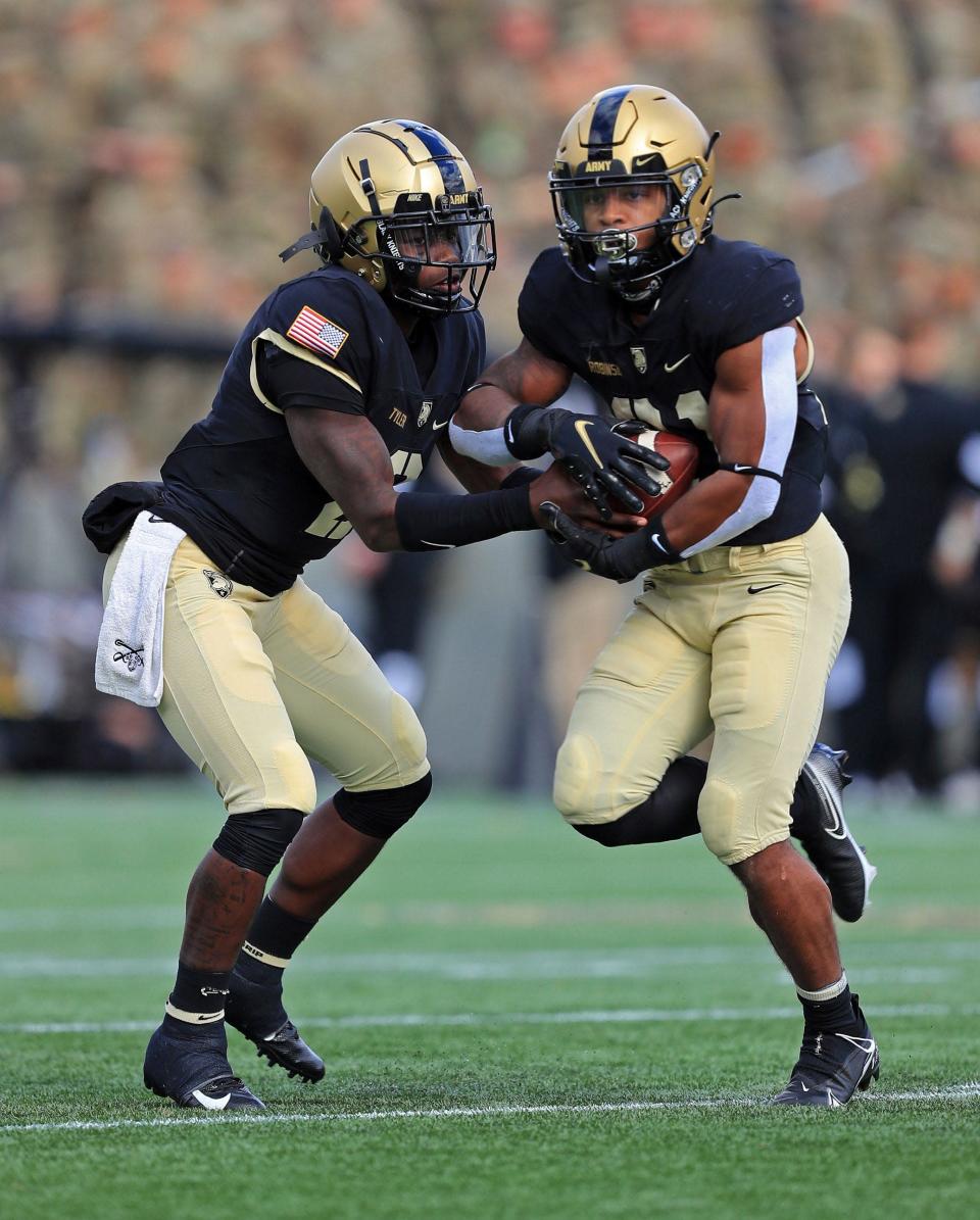 Army Black Knights quarterback Tyhier Tyler (2) hands off the ball to running back Tyrell Robinson.