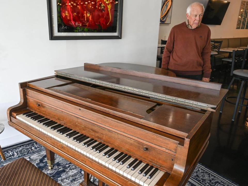 Thomas Leonard, president and CEO of Genesis Bistro & 8028 Salon, stands near the bistro’s 105 year-old baby grand piano. The restaurant, which Leonard says looks to capture the feel of the old Daily Planet, features live music on the piano a couple of times a week as well as karaoke.