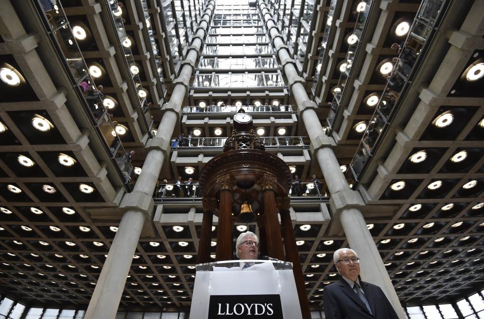 Singapore's President Tony Tan (R) listens as Lloyd's Chairman, John Nelson (C) delivers a speech at Lloyd's of London insurance market in the City of London October 24, 2014. The President of Singapore Tony Tan and his wife Mary Chee are on a four-day state visit to Britain. REUTERS/Toby Melville (BRITAIN - Tags: POLITICS BUSINESS ROYALS)