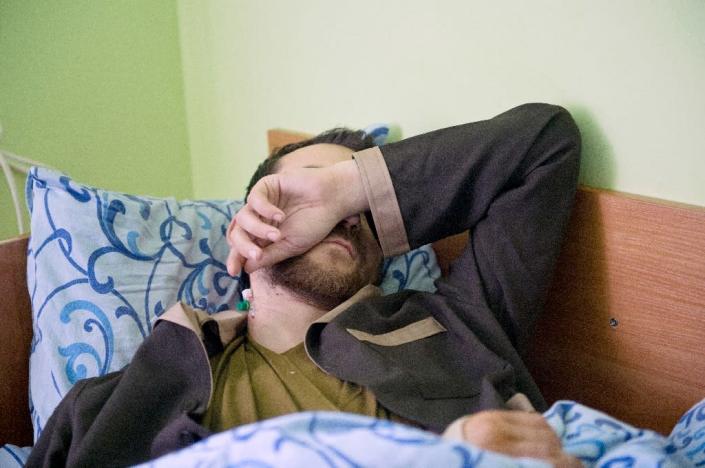 A man whom the Ukrainian security service allege to be a captured Russian soldier, covers his face as he recovers at Kiev military hospital on May 19, 2015 (AFP Photo/Genya Savilov)