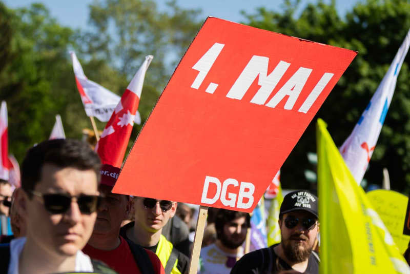 People take part in a demonstration organized by the German Trade Union Confederation (DGB) on May Day at Karl-Marx-Allee. Christoph Soeder/dpa