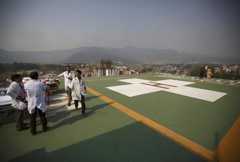 Doctors expecting arrival of the victims of a Mount Everest avalanche stand-by near the helipad at Grandi International Hospital in Kathmandu