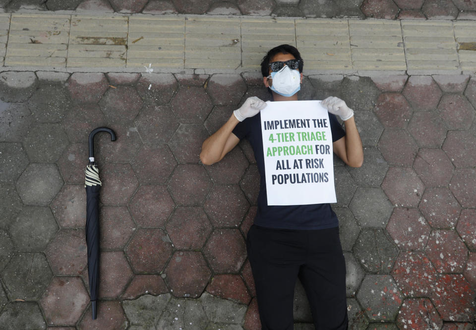 A protesters lies on the ground demanding better handling of the COVID-19 pandemic in Kathmandu, Nepal, Saturday, June 20, 2020. Hundreds participated demanding increased testing and protesting alleged corruption by government officials while purchasing equipment and testing kits. (AP Photo/Niranjan Shrestha)