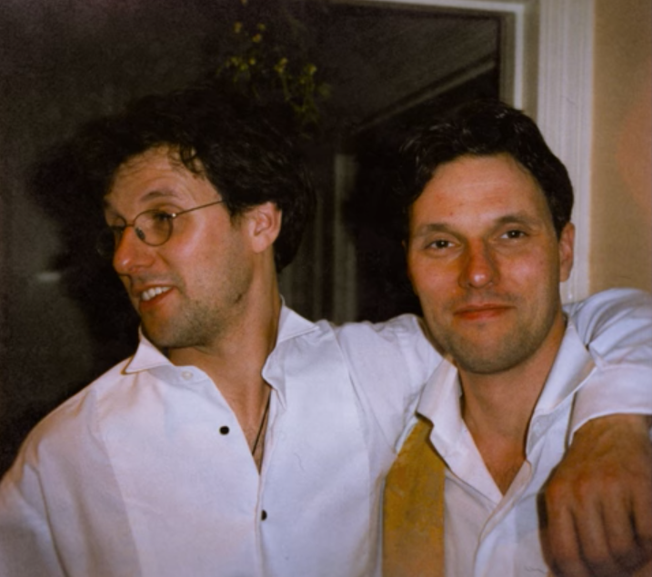 The Lewis brothers wearing white shirts in an embrace. 