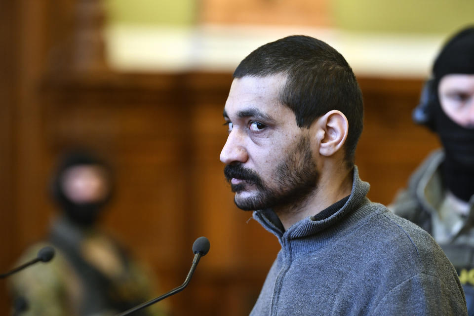 A Syrian man identified as Hassan F. arrives at the Metropolitan Court in Budapest, Hungary, Wednesday, Nov. 13, 2019. Prosecutors said the 27-year-old man identified only as Hassan F. participated in the beheading of a religious leader in the city of al-Sukhnah in Homs province and was also involved in the killings of at least 25 people. (Zsolt Szigetvary/MTI via AP)