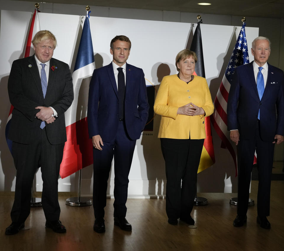 British Prime Minister Boris Johnson, French President Emmanuel Macron, German Chancellor Angela Merkel, and U.S. President Joe Biden, from left, pose for the media prior to a meeting at the La Nuvola conference center for the G20 summit in Rome, Saturday, Oct. 30, 2021. The two-day Group of 20 summit is the first in-person gathering of leaders of the world's biggest economies since the COVID-19 pandemic started. (AP Photo/Kirsty Wigglesworth, Pool)