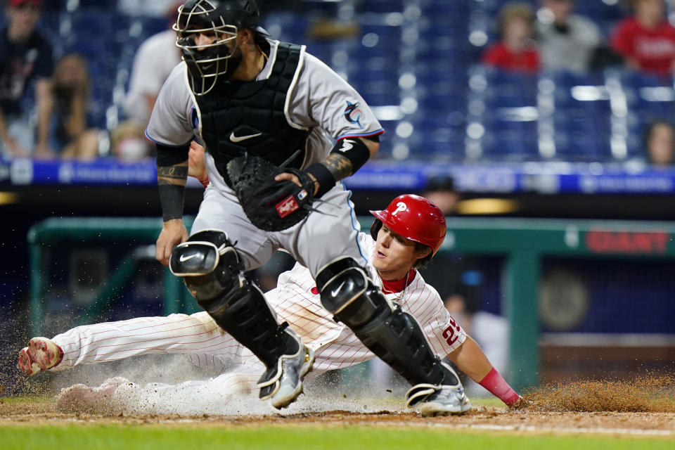 Philadelphia Phillies' Nick Maton, right, scores past Miami Marlins catcher Sandy Leon on a single by Jean Segura during the eighth inning of a baseball game, Tuesday, May 18, 2021, in Philadelphia. (AP Photo/Matt Slocum)