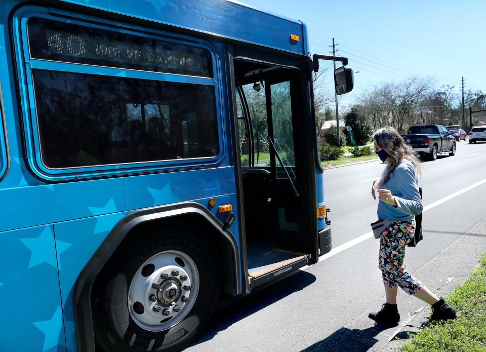 A woman who said her name is J.J. gets on an RTS bus off NW 43rd Street in Gainesville Fla. Feb. 23, 2021. The City of Gainesville is considering giving individuals over 65 and under 18 free RTS bus passes.