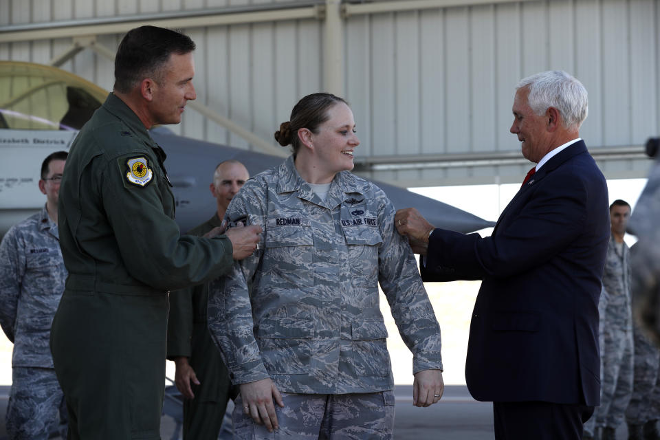 Staff Sgt. Vanessa Redman, center, is promoted to technical sergeant by Brig. Gen. Rob Novotny, left, and Vice President Mike Pence on a Nellis Air Force Base flight line in Las Vegas, Friday, Sept. 7, 2018. (Steve Marcus/Las Vegas Sun via AP)