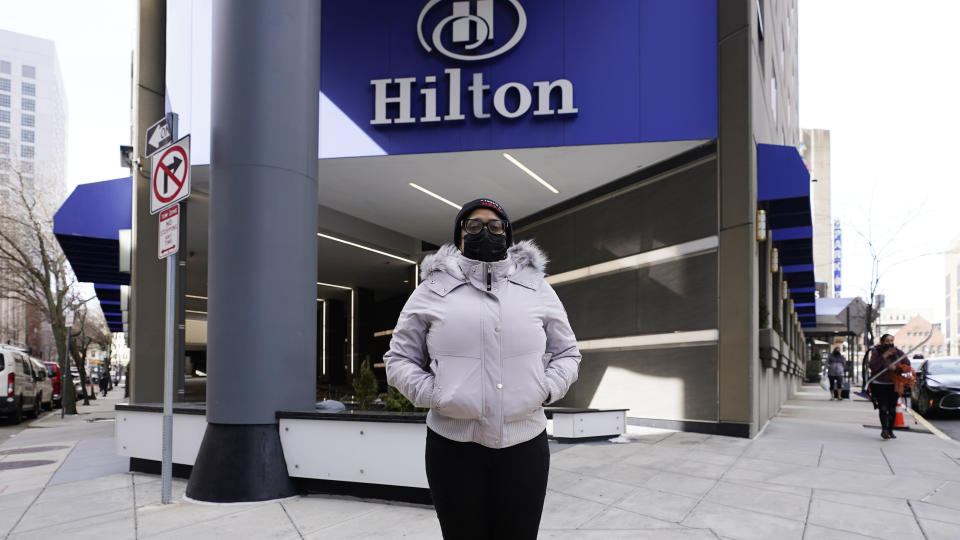 Hotel housekeeper Esther Montanez poses outside the Hilton Back Bay, Friday, March 5, 2021, in Boston. Montanez refuses to give up hope of returning to her cleaning job at the hotel, which she held for six years until being furloughed since March 2020 due to the COVID-19 virus outbreak. (AP Photo/Charles Krupa)