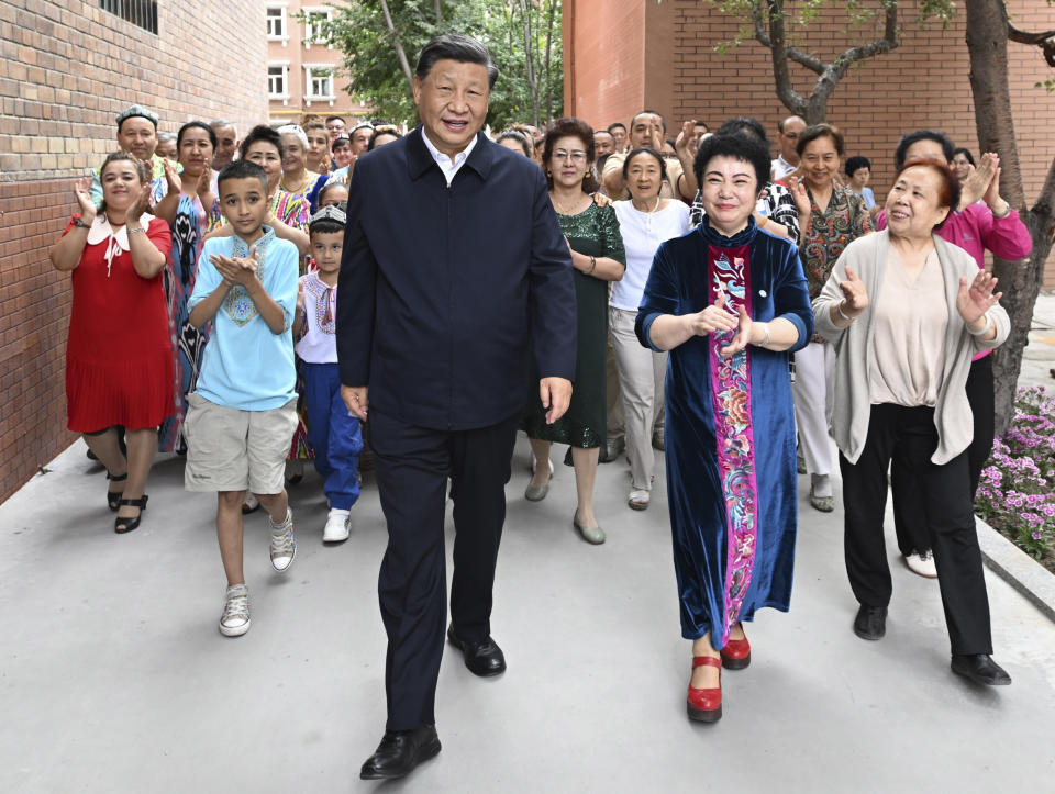 In this photo released by China's Xinhua News Agency, Chinese President Xi Jinping, center, visits the community of Guyuanxiang in the Tianshan District in Urumqi in northwestern China's Xinjiang Uyghur Autonomous Region, Wednesday, July 13, 2022. (Xie Huanchi/Xinhua via AP)