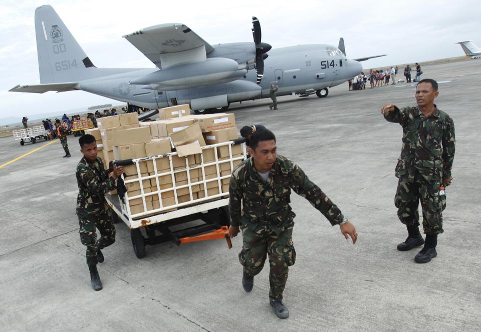 Military personnel deliver aid supplies at the destroyed airport after super typhoon Haiyan battered Tacloban City, in central Philippines