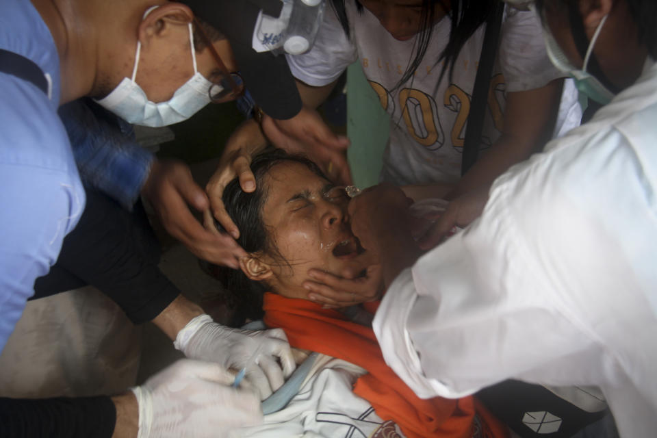In this March 2, 2021, file photo, a woman who got tear gas in her eyes is treated by a nurse during an anti-coup protest in Yangon, Myanmar. Myanmar's security forces have killed scores of demonstrators protesting a coup. The outside world has responded so far with tough words, a smattering of sanctions and little else. (AP Photo, File)