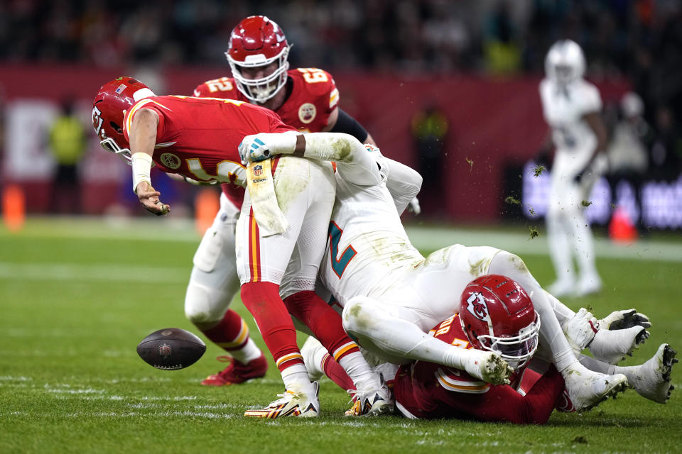 Kansas City Chiefs quarterback Patrick Mahomes, left, fumbles as he is hit by Miami Dolphins linebacker Bradley Chubb (2) during the second half of an NFL football game Sunday, Nov. 5, 2023, in Frankfurt, Germany. The Dolphins recovered the fumble. (AP Photo/Martin Meissner)