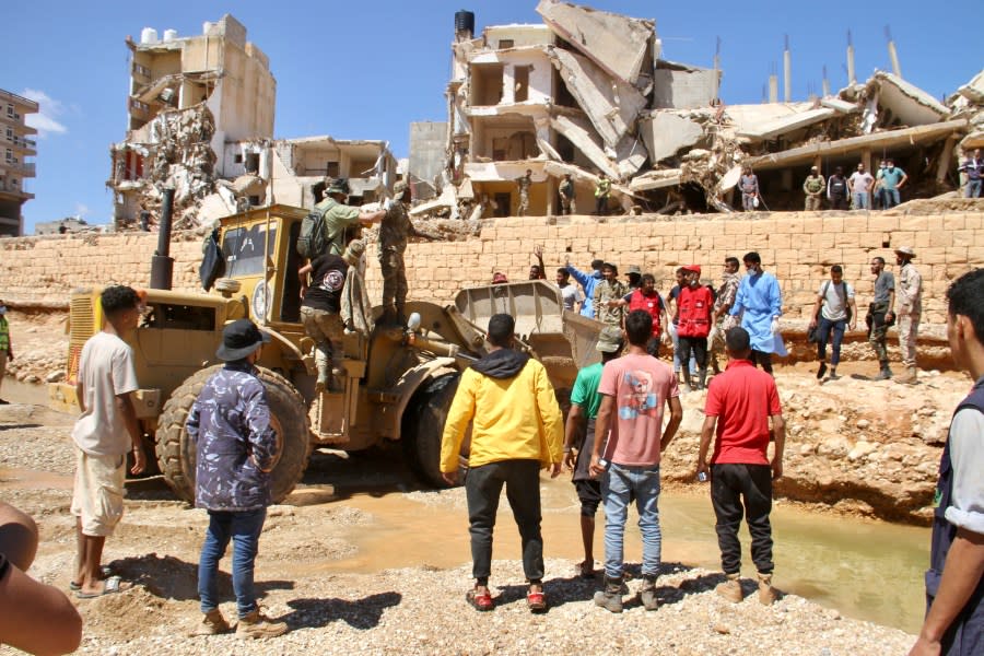 People look for survivors in Derna, Libya, Wednesday, Sept.13, 2023. Search teams are combing streets, wrecked buildings, and even the sea to look for bodies in Derna, where the collapse of two dams unleashed a massive flash flood that killed thousands of people. (AP Photo/Yousef Murad)