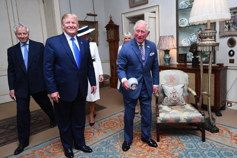 Prince Charles picks up a diffuser that fell off a photographer's flash with Trump