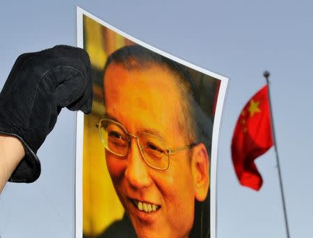 A protester holds an image of jailed dissident Liu Xiaobo outside the Chinese Embassy in Oslo, Norway December 9, 2010. REUTERS/Toby Melville/Files
