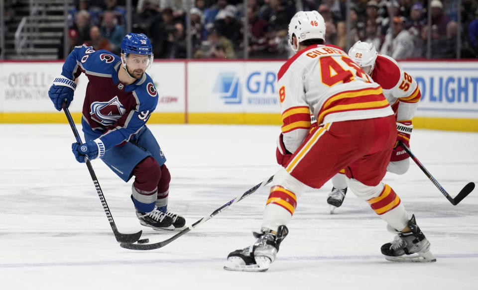Colorado Avalanche left wing Tomas Tatar, left, drives past Calgary Flames defenseman Dennis Gilbert in the first period of an NHL hockey game, Monday, Dec. 11, 2023, in Denver. (AP Photo/David Zalubowski)