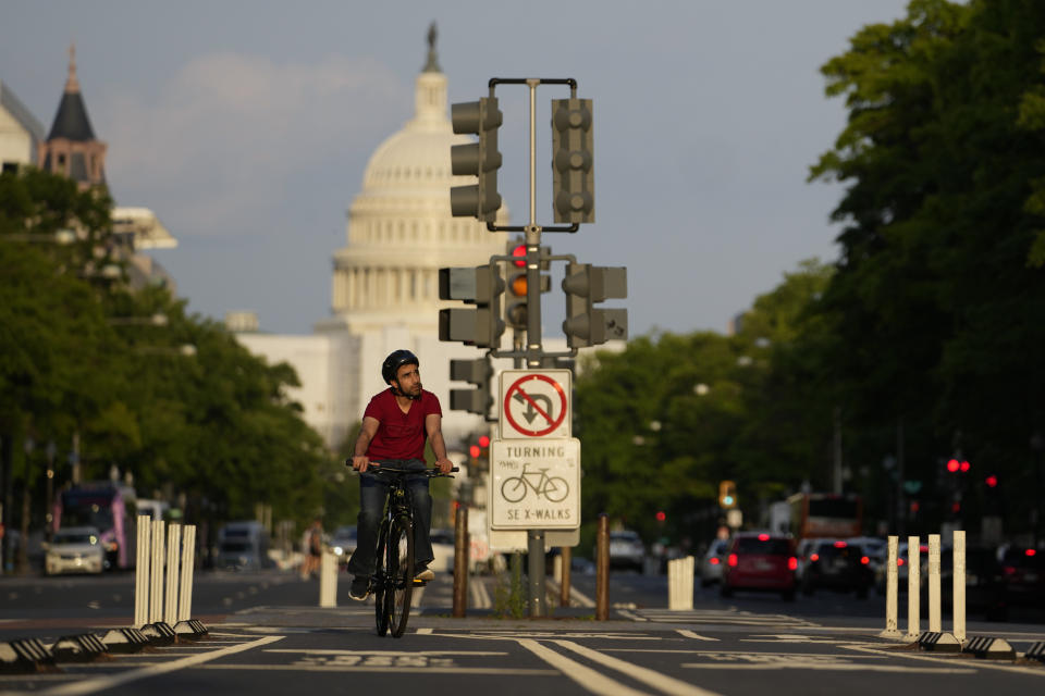 A cyclist rides up Pennsylvania Avenue with the U.S. Capitol seen in the distance in Washington, Monday, May 8, 2023. In 2001, the nation's capital offered cyclists a meager 3 miles of bicycle lanes, unprotected. By 2019, the network topped 100 miles, and the share of all trips by bicycle increased fivefold. In 2020 and 2021, the city picked up the pace even more, building nearly 20 miles of protected lanes, much safer than merely marked lanes on streets shared with cars. (AP Photo/Carolyn Kaster)