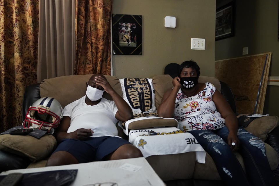 Mary and Barrett Duplessis speak during an interview with The Associated Press in their home in New Orleans, Wednesday, Aug. 19, 2020. Levee breaches following Hurricane Katrina dumped 6 feet of water into the home of Mary Duplessis and her husband in 2005. She remembers lots of paperwork and bureaucracy in her Katrina recovery, and she recalls the scenes of misery at a convention center where thousand were trapped without power or running water. But, for her, COVID-19, has been worse. (AP Photo/Gerald Herbert)