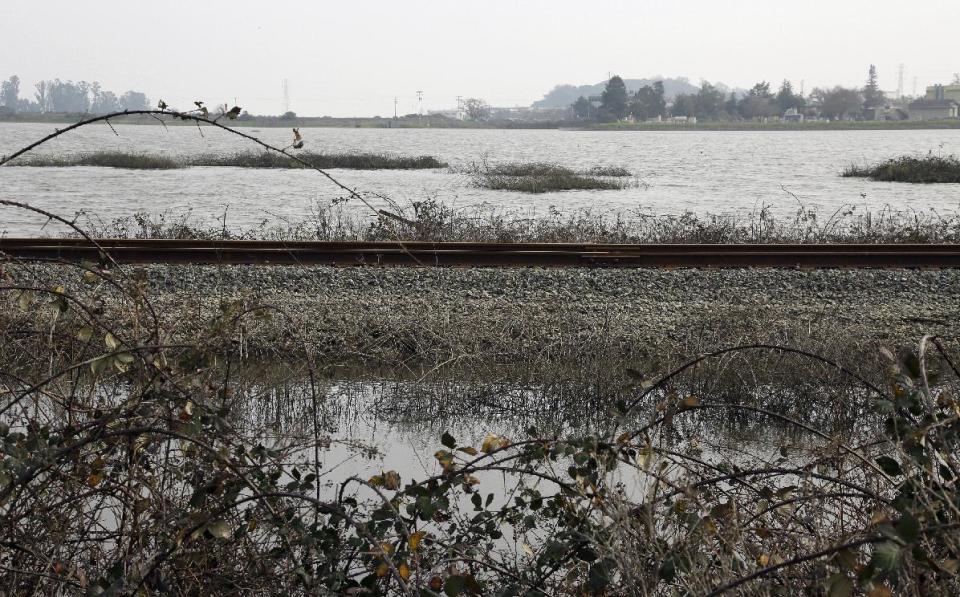 In this Tuesday, Jan. 17, 2017, photo, a field remains flooded along Highway 37 near Novato, Calif. California, under Gov. Jerry Brown, is a leader in fighting climate change. But climate experts say this winter's storms are underscoring how much work even California has yet to do to prepare for sea rise. (AP Photo/Eric Risberg)