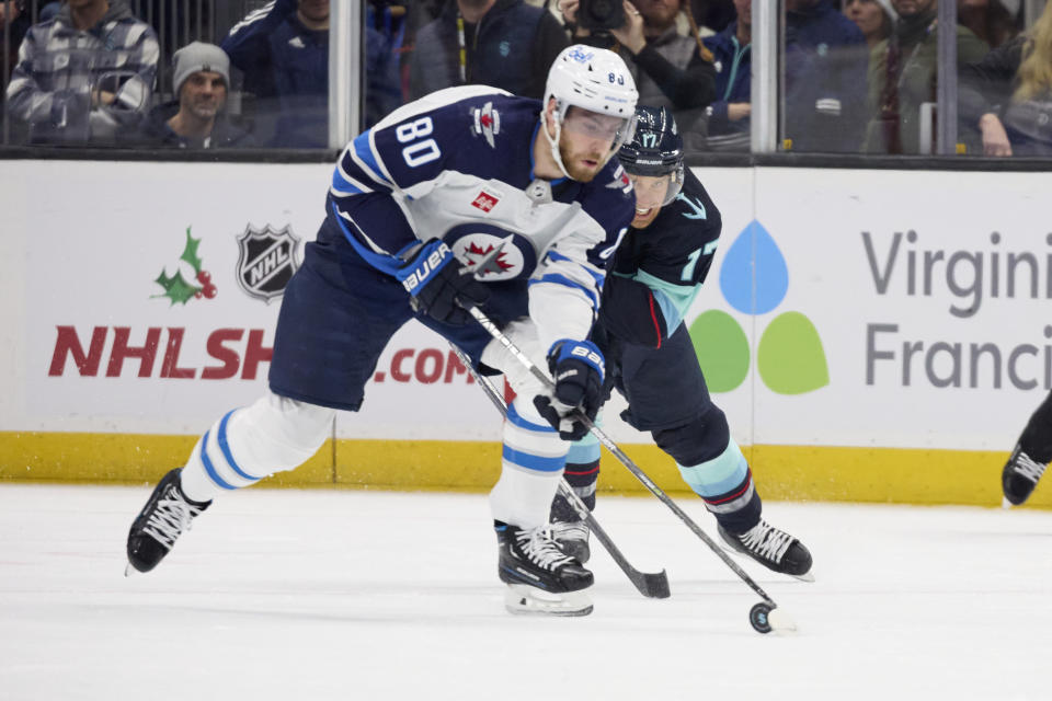 Winnipeg Jets left wing Pierre-Luc Dubois (80) skates with the puck while Seattle Kraken center Jaden Schwartz (17) defends during the first period of an NHL hockey game, Sunday, Dec. 18, 2022, in Seattle. (AP Photo/John Froschauer)