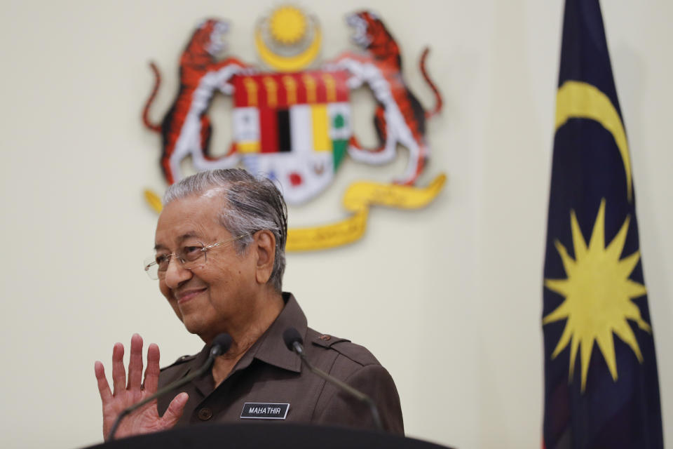 FILE - In this April 15, 2019, file photo, Malaysian Prime Minister Mahathir Mohamad waves good bye to media after a press conference in Putrajaya, Malaysia. Former Prime Minister Mahathir has been ousted from his Malay party in the latest twist to a power struggle with his successor Muhyiddin Yassin, but he has vowed to challenge the move. The 94-year-old Mahathir, along with his son and three other senior members, were expelled from the Bersatu party on Thursday, May 28, 2020. (AP Photo/Vincent Thian, File)