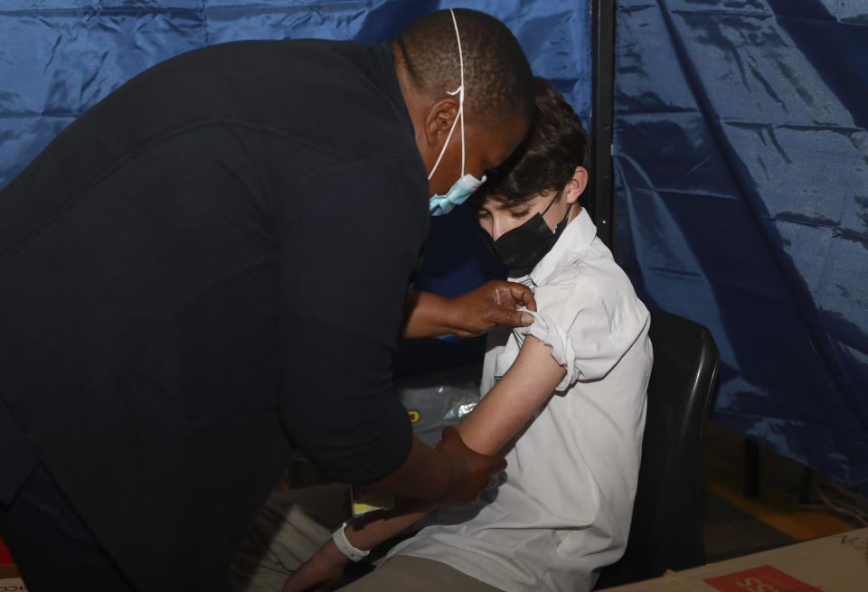 13-year-old Zak Power receives a first dose of the Pfizer COVID-19 vaccine at the Vaccination Centre of Hope at the Cape Town International Convention Centre in Cape Town, South Africa, Wednesday Oct. 20, 2021. South Africa has started giving COVID-19 vaccinations to adolescents aged between 12 and 17 years, with a goal of inoculating at least 6 million people from this age group. (AP Photo/Nardus Engelbrecht)