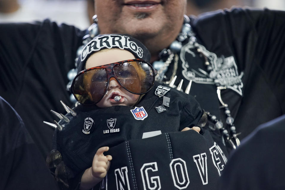 A Las Vegas Raiders fan wears a dressed up doll during the third day of the NFL draft Saturday, April 30, 2022, in Las Vegas. (AP Photo/John Locher)