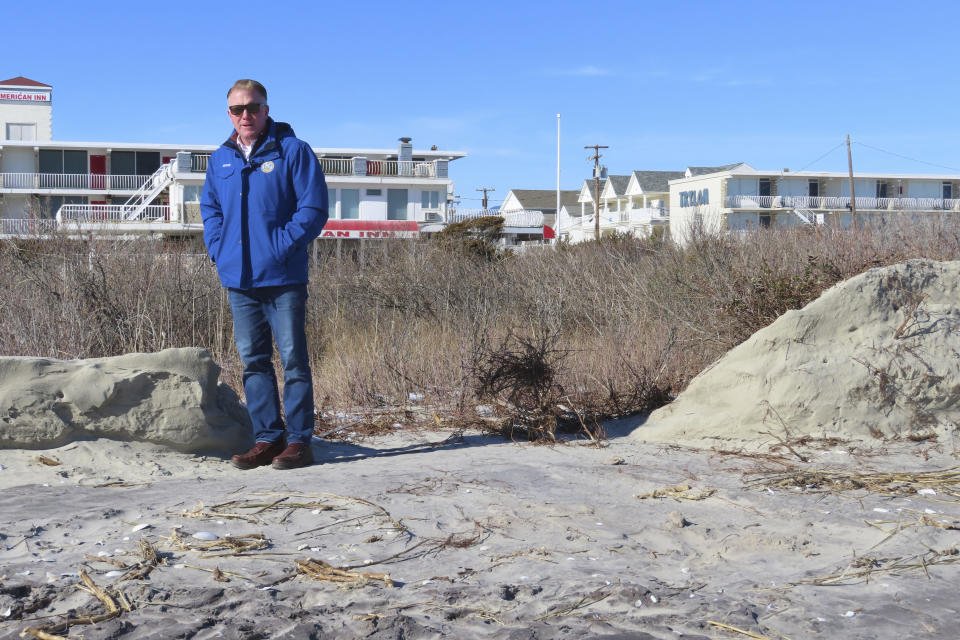 Mayor Patrick Rosenello stands next to a destroyed section of sand dune in North Wildwood N.J. on Jan. 22, 2024. A recent winter storm punched a hole through what is left of the city's eroded dune system, leaving it more vulnerable than ever to destructive flooding as the city and state fight in court over how best to protect the popular beach resort. (AP Photo/Wayne Parry)