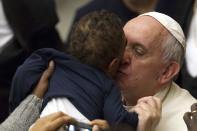 Pope Francis kisses a child during an audience with children, assisted by volunteers of Santa Marta institute, in Paul VI hall at the Vatican December 14, 2013. REUTERS/Giampiero Sposito (VATICAN - Tags: RELIGION)