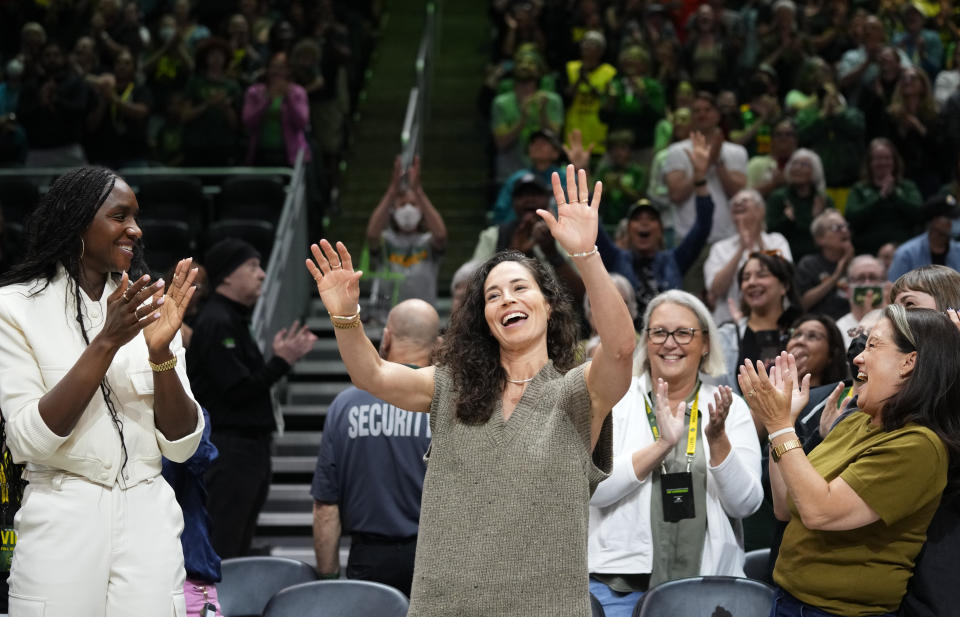 Former Seattle Storm player Sue Bird, center, acknowledges the crowd as former teammate and Storm player Crystal Langhorne, left, and CEO & team president Alisha Valavanis, right, clap during the first half of a WNBA basketball game between the Storm and the Las Vegas Ace, Saturday, May 20, 2023, in Seattle. (AP Photo/Lindsey Wasson)