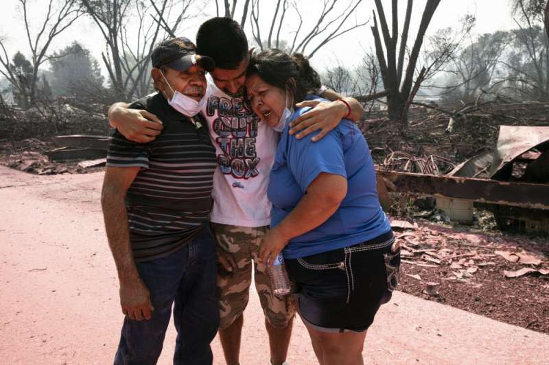 美國奧勒岡州大火蔓延，房屋被燒毀的家庭相擁而泣。（AP）