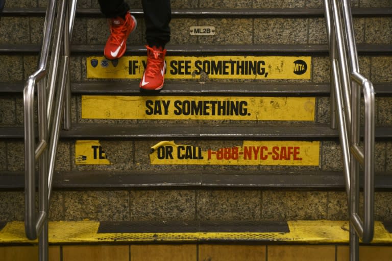 A message about security is visible on stairs inside the Times Square subway station